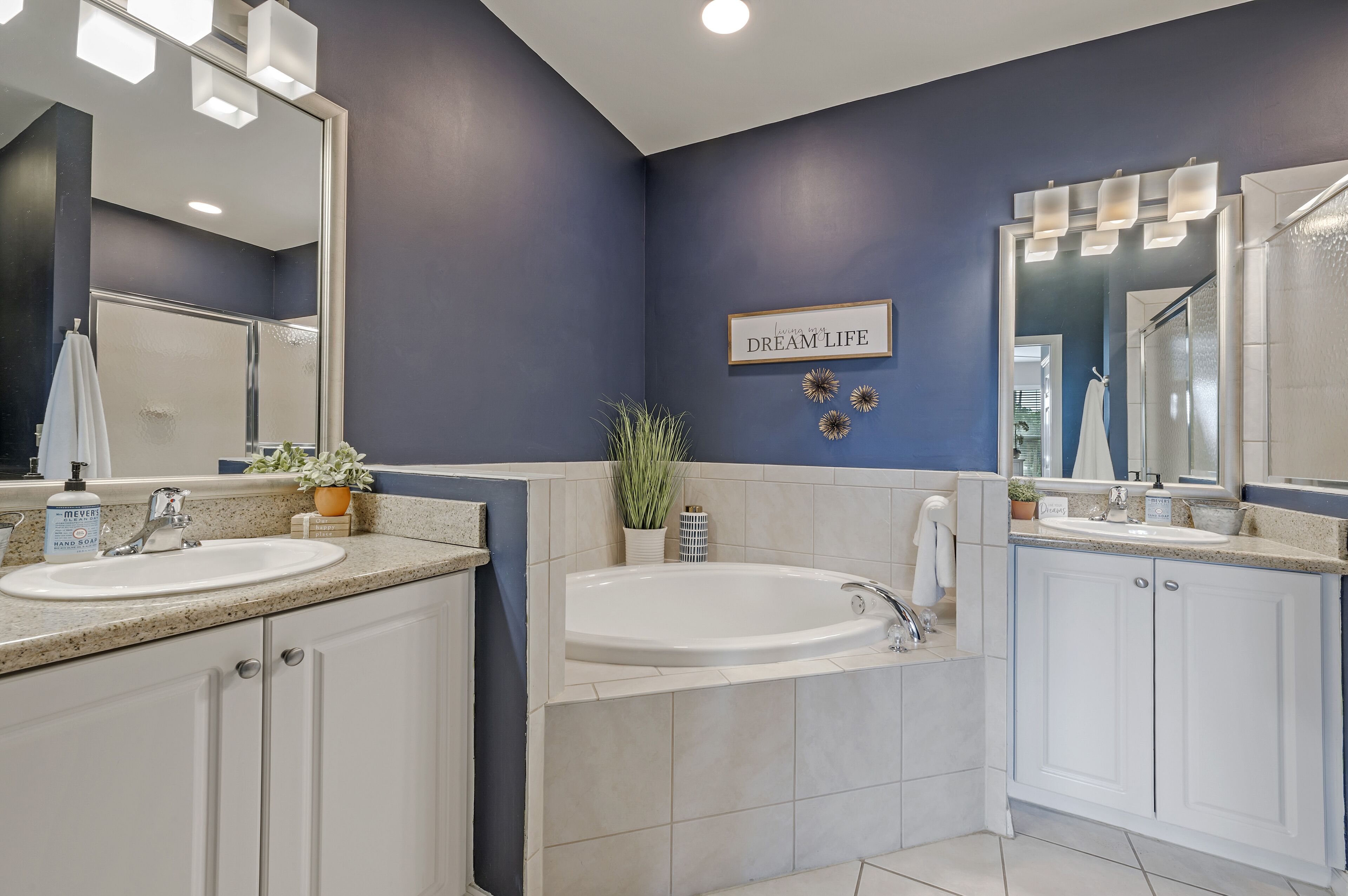 A modern bathroom with two sinks, a large mirror, and a 'Dream Life' sign.