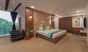Un dormitorio moderno con una cama grande, un escritorio, una silla, una planta en maceta y vistas al exterior.