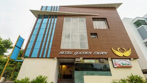 Facciata moderna di un hotel con un cartello ben visibile che riporta la scritta "HOTEL GOLDEN SWAN".