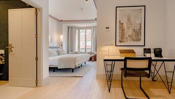 Una habitación de hotel moderna con cama, escritorio, silla y una obra de arte en la pared.