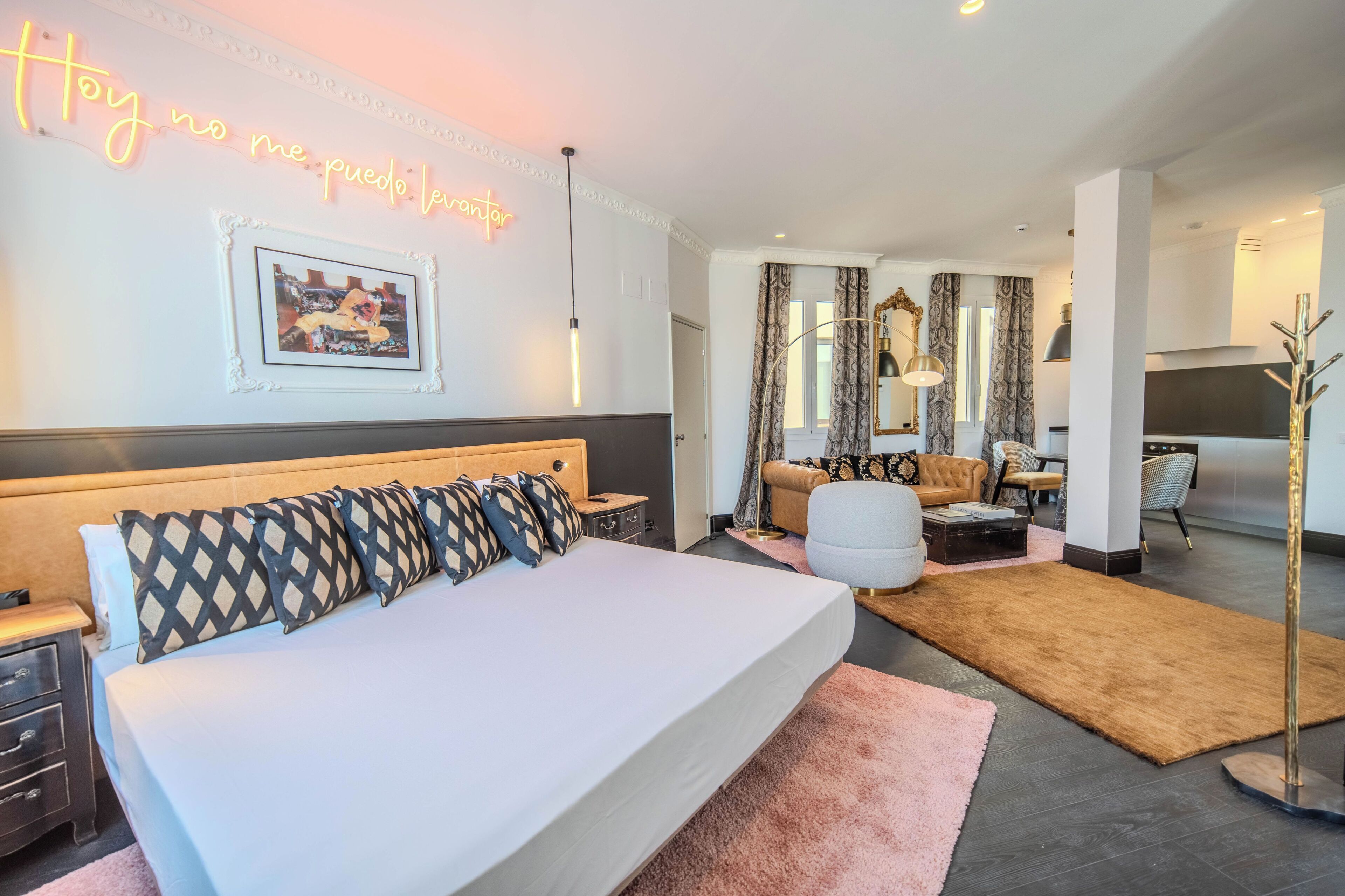 Una camera d'albergo moderna con un letto grande, una scrivania, un divano e un'area pranzo.