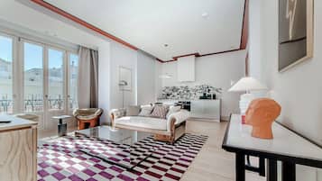 Una sala de estar moderna con un sofá, una mesa de centro y una alfombra estampada.