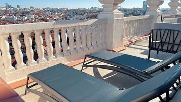 Un balcón con dos sillones de relax y vista a la ciudad.