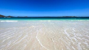 A beach with clear turquoise water and white sand.