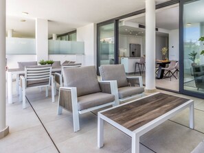A modern outdoor seating area with white furniture and a wooden coffee table. - Cameron | pool - garden - sea views (Fuengirola)