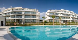 A modern hotel with a pool, featuring curved balconies and a clear blue pool. - Cameron | pool - garden - sea views (Fuengirola)
