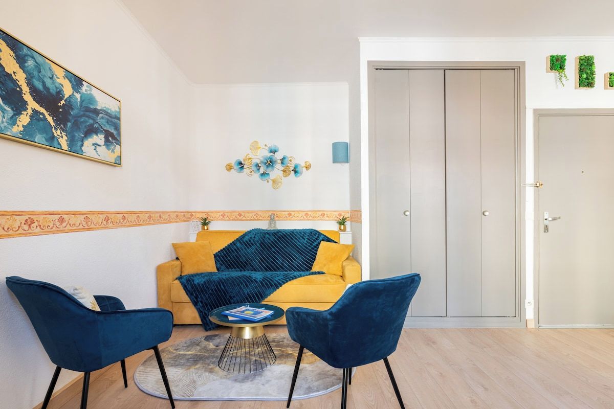 A living room with a sofa, two chairs, a coffee table, and a decorative wall piece.