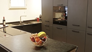 A kitchen with a fruit bowl on the counter, a sink, and a stove. - Sauvageau - 1 chambre avec parking (Burdeos)