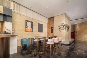 A modern interior with a reception desk, bar area, and seating.