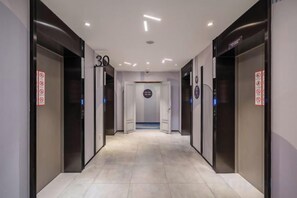 A hallway with multiple elevators, each marked with a number.