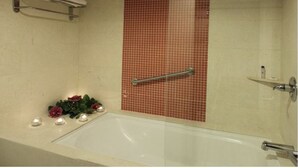 A bathroom with a bathtub, a handrail, and a tiled wall. - Hotel Tiburon (Guadalajara)