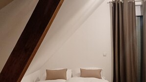 A bedroom with a bed, pillows, and curtains. - The Mediterrean apartment in the Wine Town Hessigheim, modern and stylish. (Hessigheim)