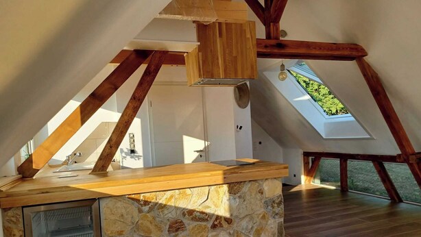 A kitchen with a stone island, wooden beams, and skylights. - The Mediterrean apartment in the Wine Town Hessigheim, modern and stylish. (Hessigheim)