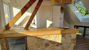 A kitchen with a stone island, wooden beams, and a skylight. - The Mediterrean apartment in the Wine Town Hessigheim, modern and stylish. (Hessigheim)