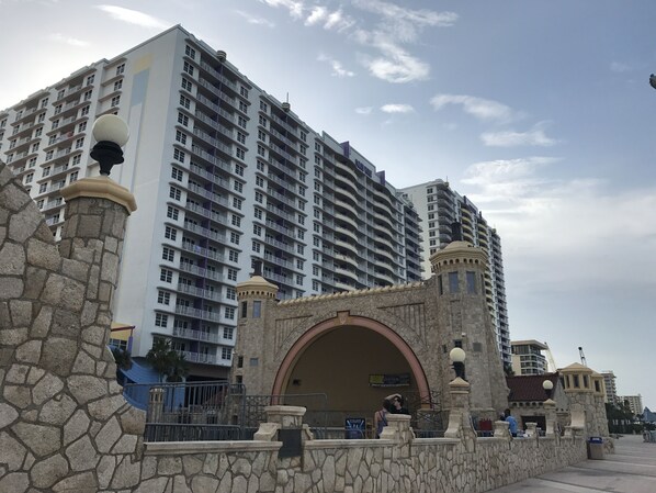A high-rise hotel with multiple balconies and a stone archway entrance.