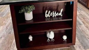 A kitchen with a dark wooden island, a potted plant, and a 'blessed' sign. - Vacation Farmhouse (Lufkin)