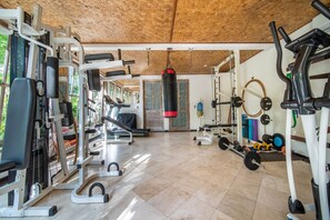 A gym with various exercise equipment, including weight machines, a punching bag, and free weights.
