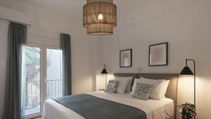 Une chambre moderne avec un grand lit, deux lampes de chevet et un luminaire suspendu.