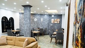 A modern interior with a sofa, dining tables, and chairs. - İdeal Butik Otel (Arnavutköy)