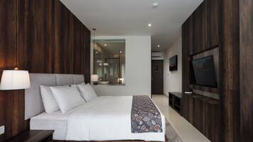 A modern bedroom with a large bed, a TV, and a mirror.