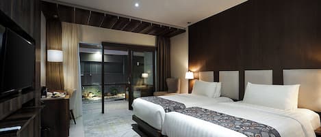 Quarto de hotel com uma cama grande, televisão, escrivaninha e vista para a piscina.