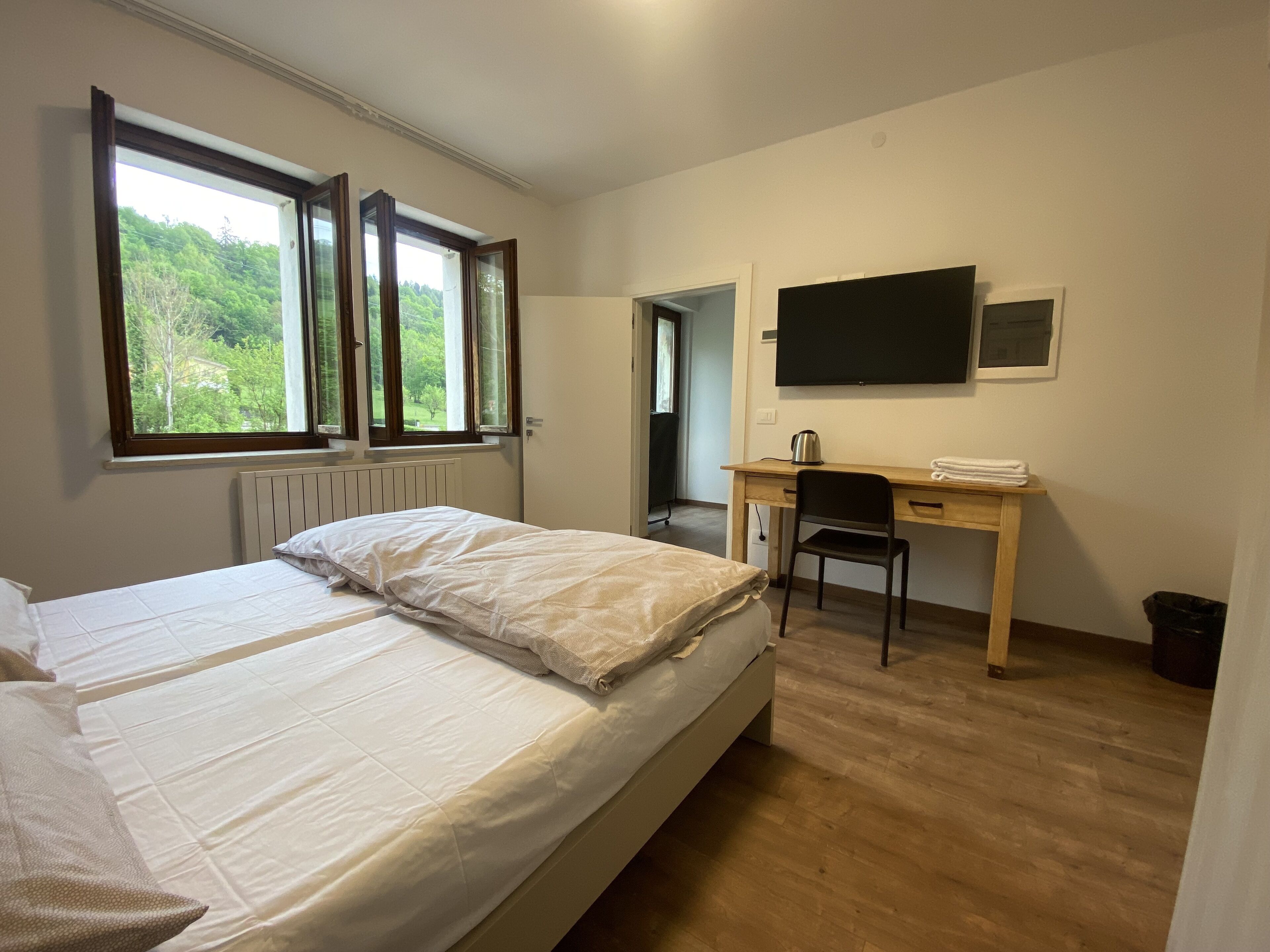 Une chambre à coucher avec un lit, un bureau et un téléviseur.