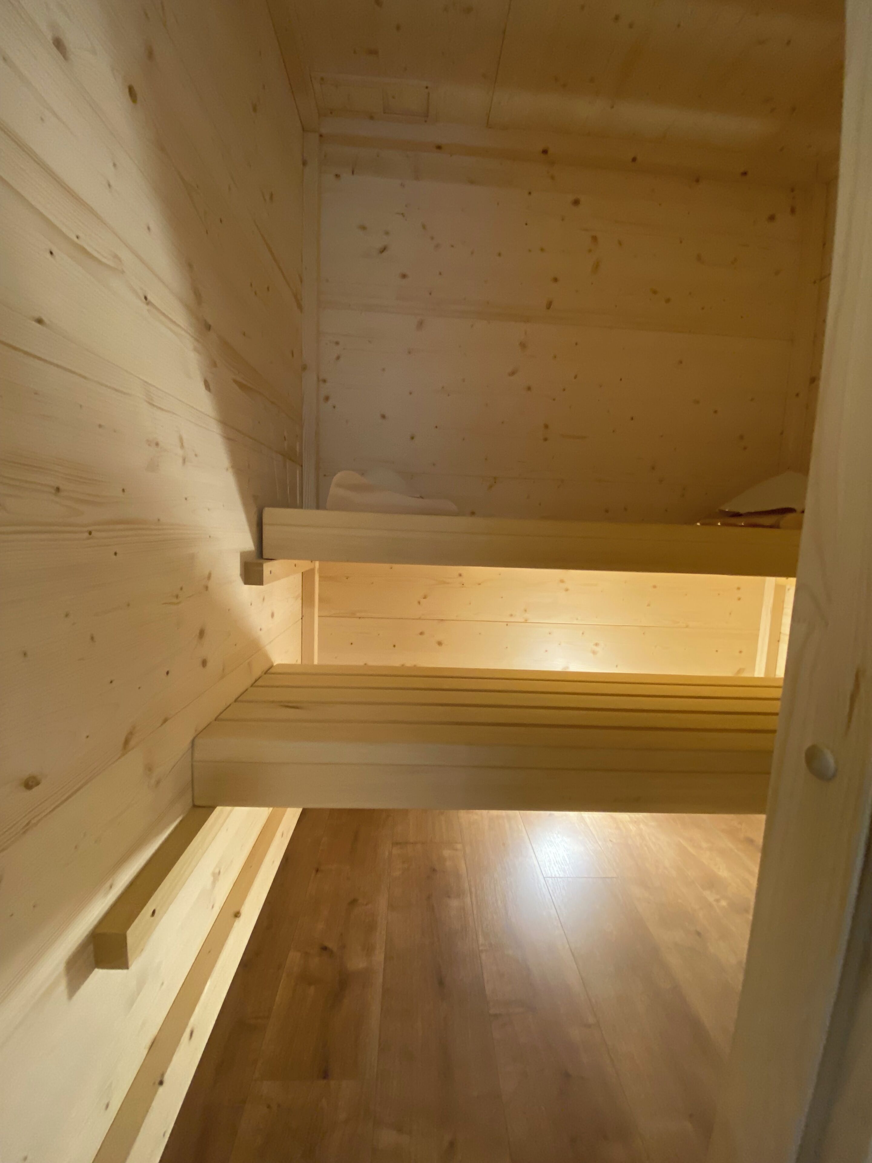 Ein Holzinnenraum mit schrägverdeckter Decke und einer integrierten Sitzbank.