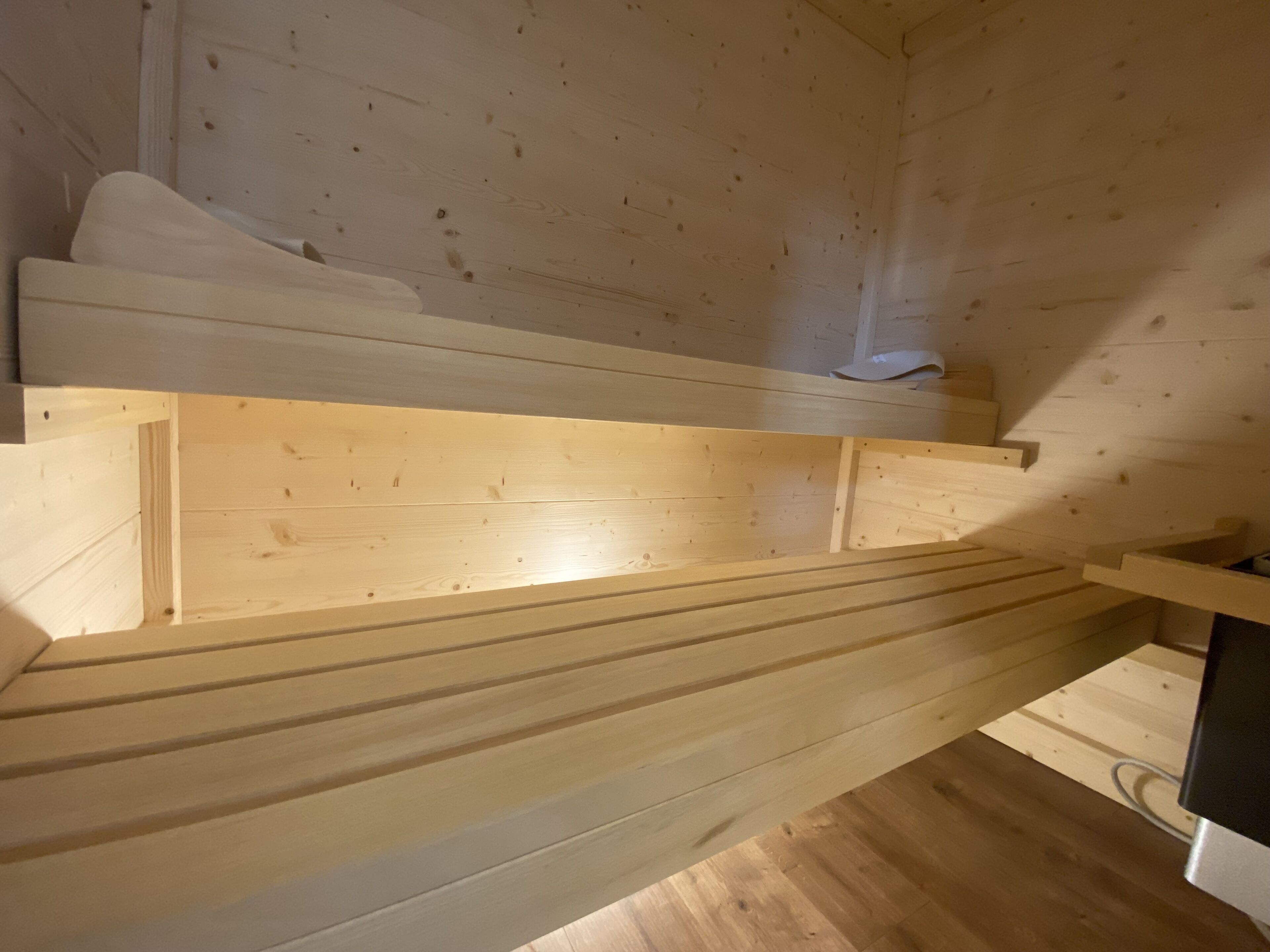Un intérieur en bois avec un lit superposé et un espace bureau.