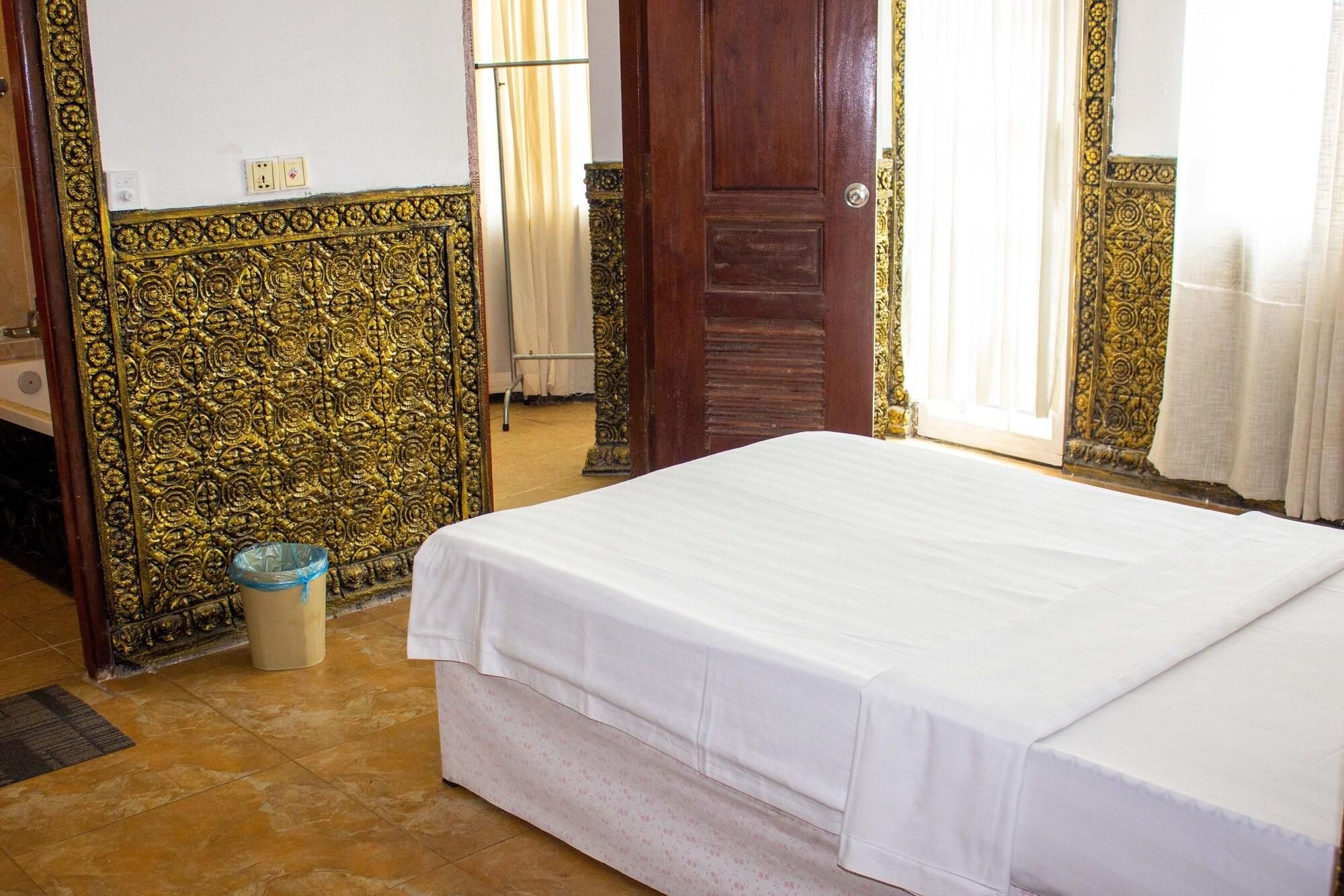Una habitación con cama, puerta de madera, espejo y paredes con diseño.