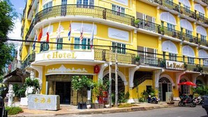 Un hôtel jaune, doté de balcons, sur lequel on peut lire l’inscription « Le Hotel ».