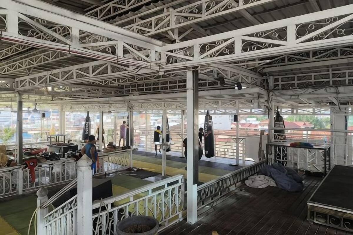 Een openluchtpaviljoen met een metalen constructie, een centraal podium en uitzicht op de stad.