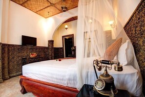 Een slaapkamer met een bed, telefoon en televisie.