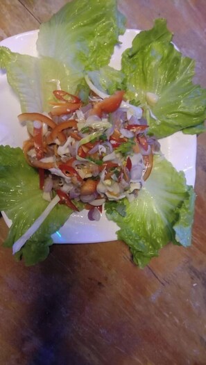 Un piatto di insalata con foglie di lattuga e diversi ortaggi.