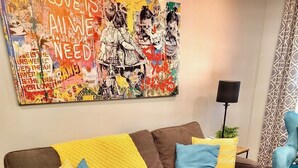 A brown sofa with yellow and blue cushions, a patterned rug, and a black coffee table.