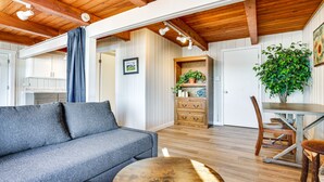 A cozy living room with a grey sofa, wooden dining table, and a large plant. - Lakefront Osceola Vacation Rental - Dogs Welcome! (Osceola)