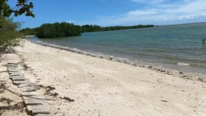 Una playa con cielo despejado y mar tranquilo.