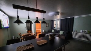 Une cuisine moderne dotée d’un îlot central, de luminaires suspendus et d’un coin repas.