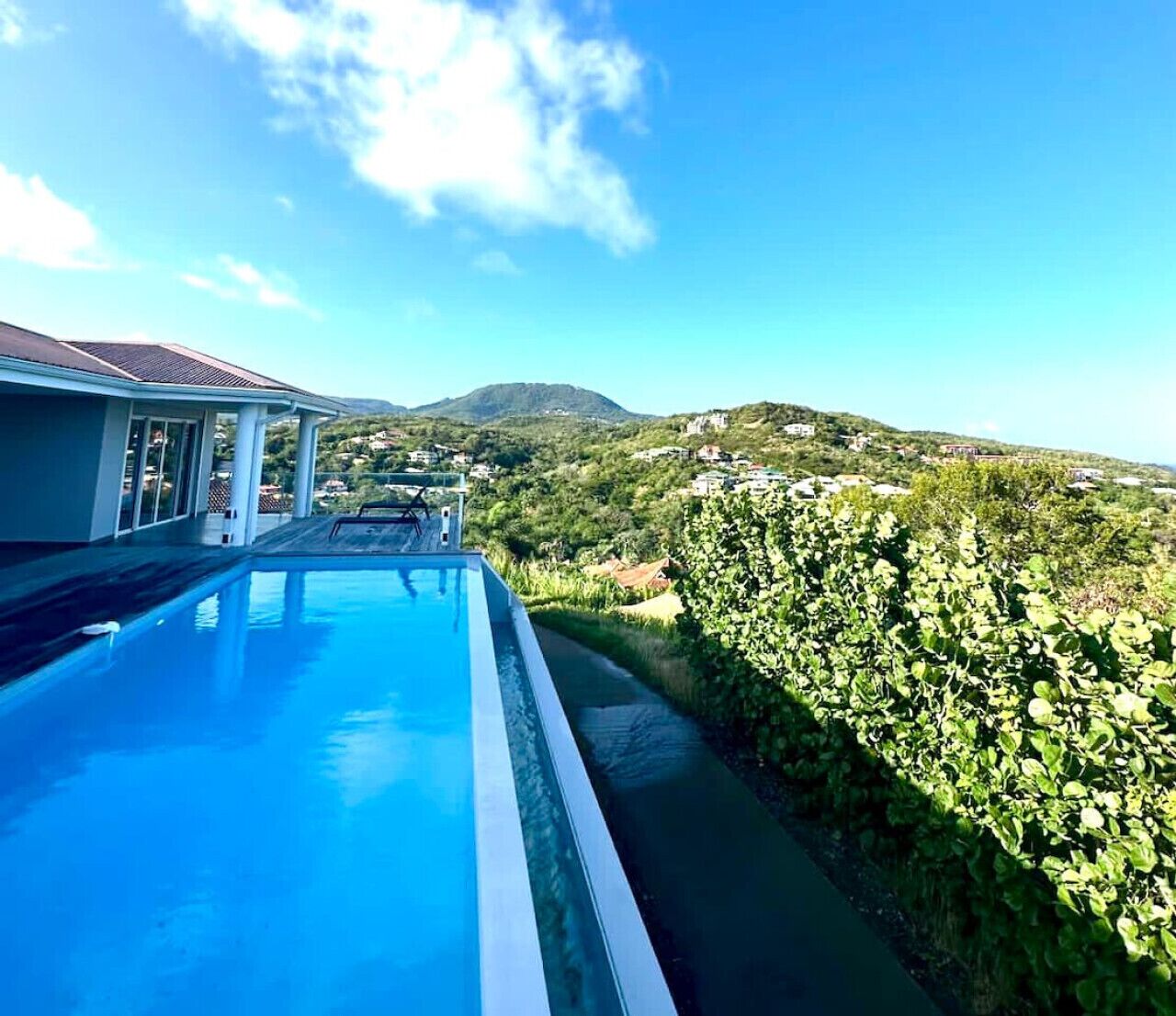 Una piscina con vistas a un paisaje montañoso y un edificio de techo inclinado.