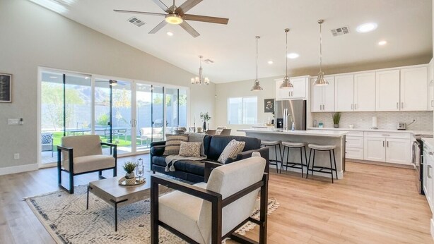 A spacious living area with a sofa, coffee table, and a dining area with bar stools.