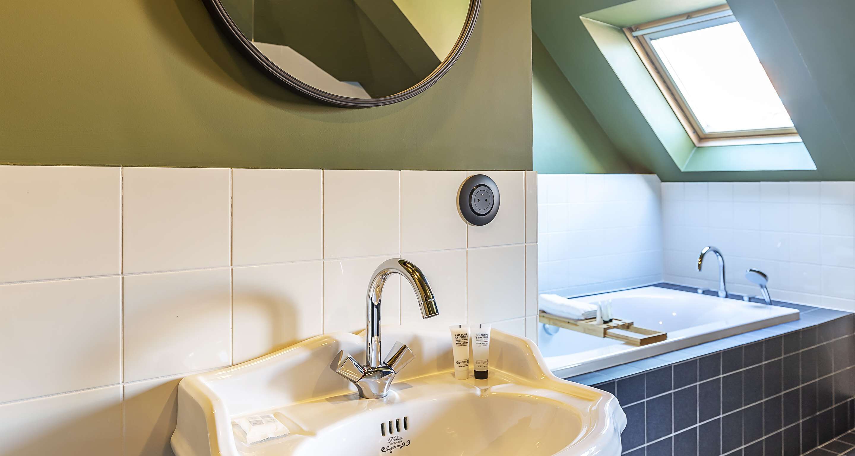 Une salle de bain avec un lavabo, un miroir et une vue sur une baignoire.