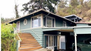 A two-story house with a covered porch and a car parked in the driveway. - Cozy Lake View Experience (Klamath Falls)