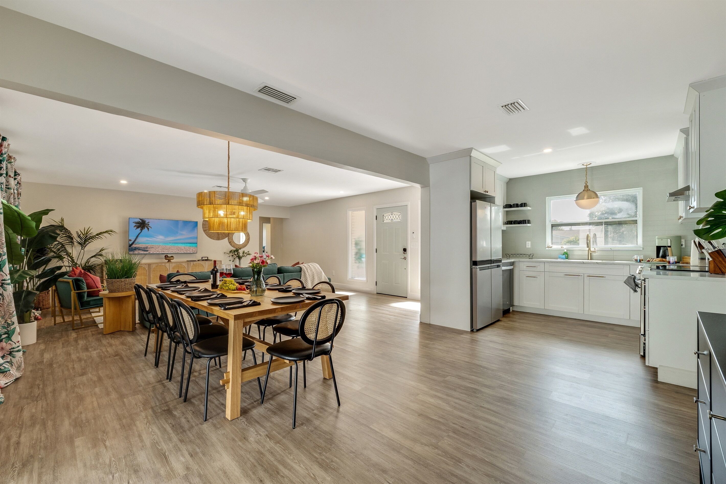 A spacious living area with a dining table, chairs, and a kitchen area with modern appliances.