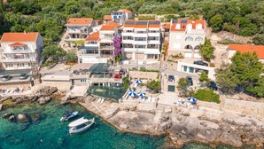 Un pueblo costero con edificios de piedra, aguas cristalinas y barcos.