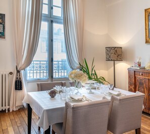 A dining room with a table set for four, a radiator, a window with curtains, and a plant. - "Les Effrontés" *** Louis Blanc, Charming Apartment (Limoges)