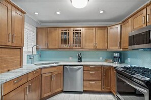 Kitchen features a microwave, gas stove, and stainless steel dishwasher.