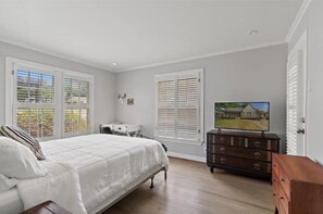 Cozy retreat with a large bed, TV, and dresser.