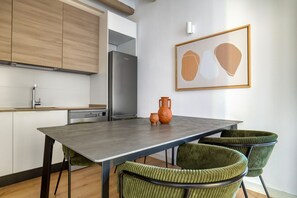 Enjoy cooking in this well-equipped kitchen with a sink, stainless steel refrigerator, and wooden cabinets.