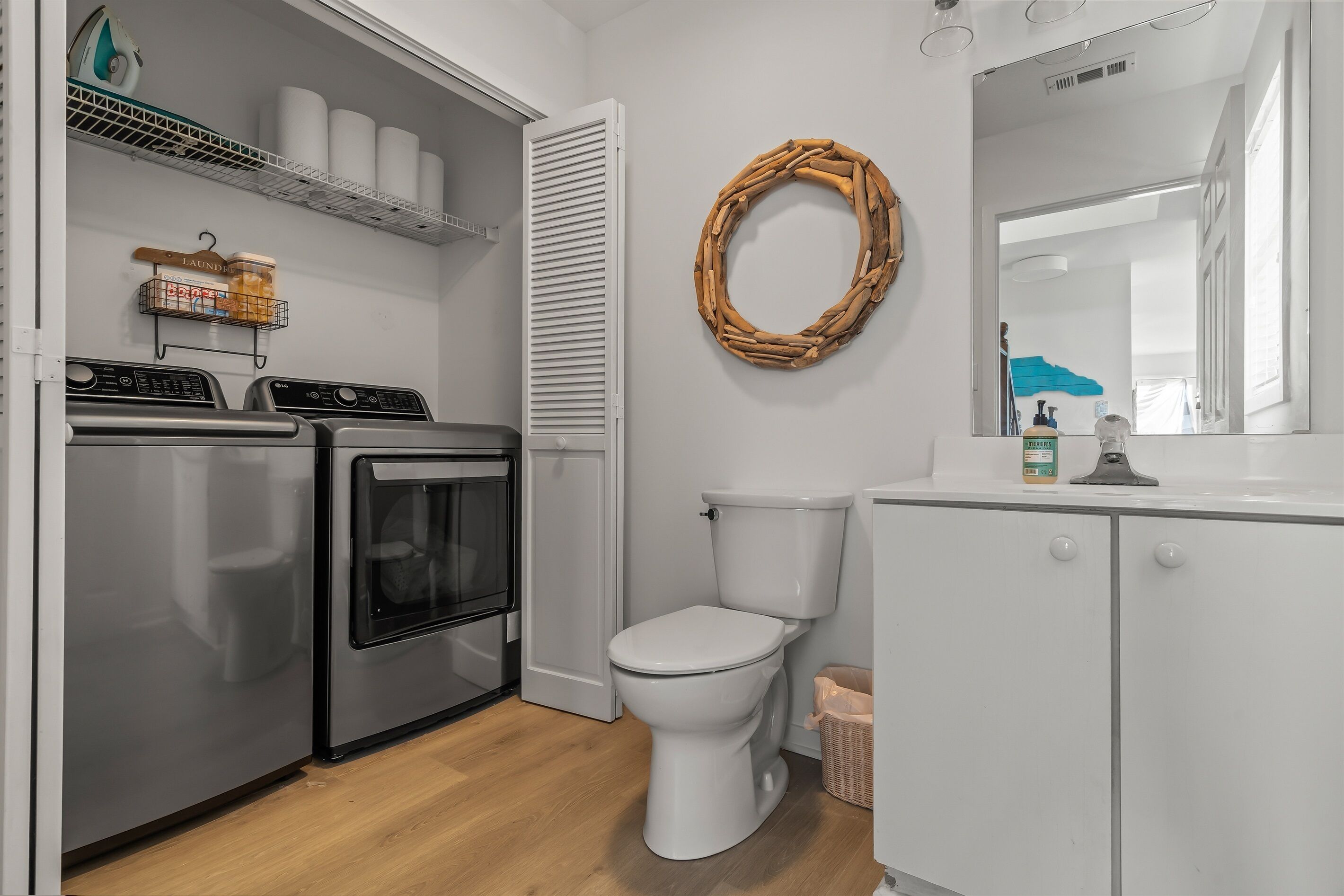 A compact laundry room with a washing machine, dryer, and a toilet.