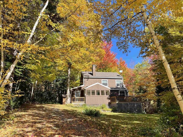 A two-story house with a front porch and a satellite dish.