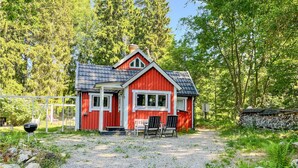 A red wooden house with a gravel driveway and two black chairs outside. - Cozy home in örebro with WiFi (Örebro)